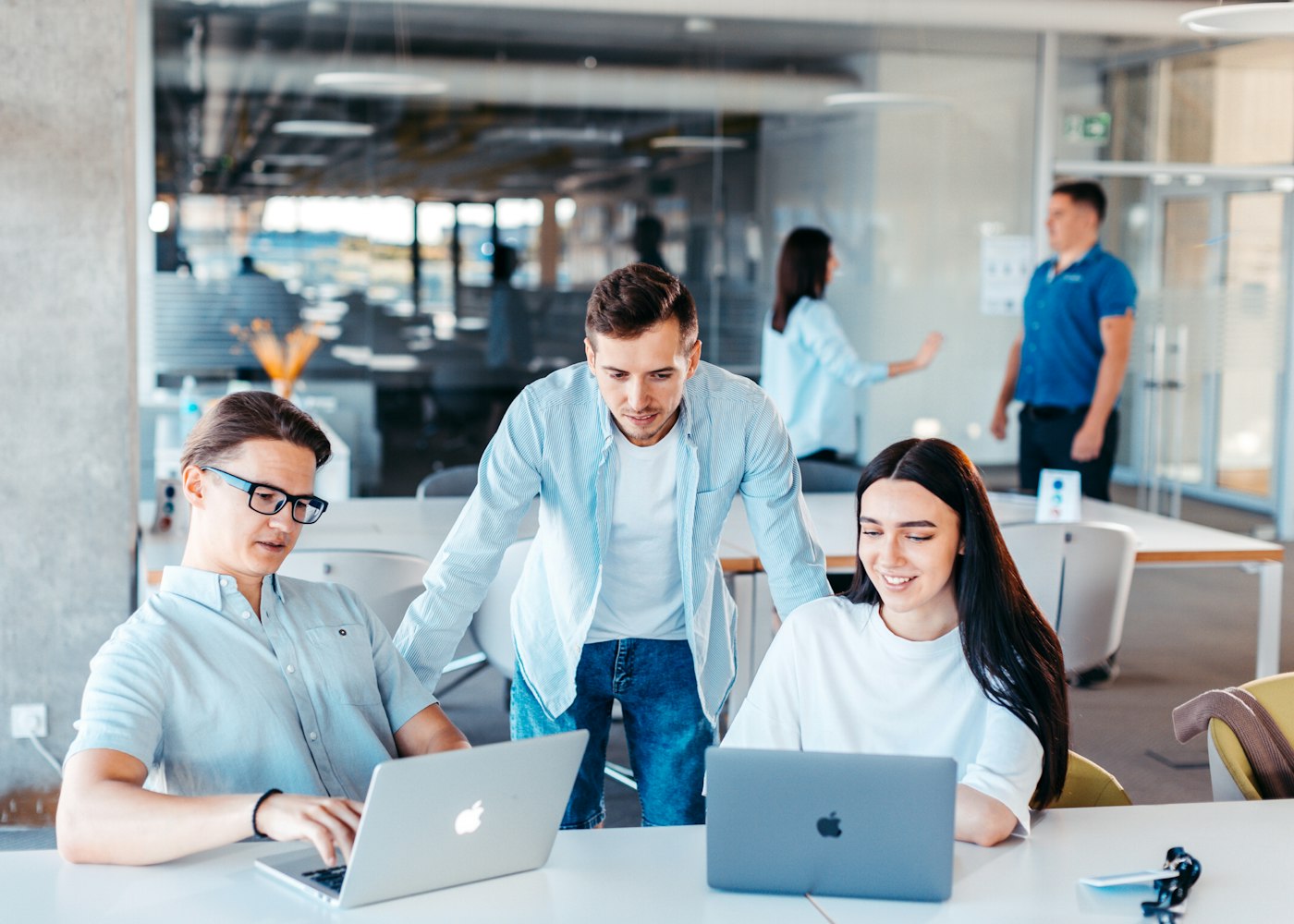 Colleagues working together at laptops in an open-plan office